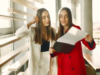 молоді жінки розглядають папери в офісі