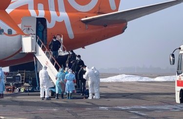 Украинцы с Китая выходят из самолета в Харькове. Фото: ГПСУ