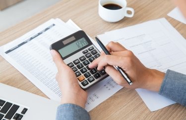 У банках скоротилася частка проблемних кедитів. / Freepik калькулятор, документи, чашка кави